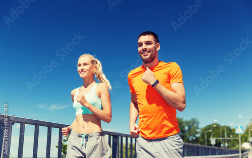 smiling couple running at summer seaside