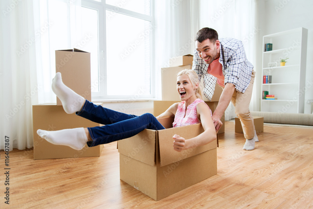 couple with cardboard boxes having fun at new home couple with cardboard boxes having fun at new home