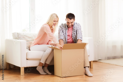 happy couple with cardboard box or parcel at home © Syda Productions