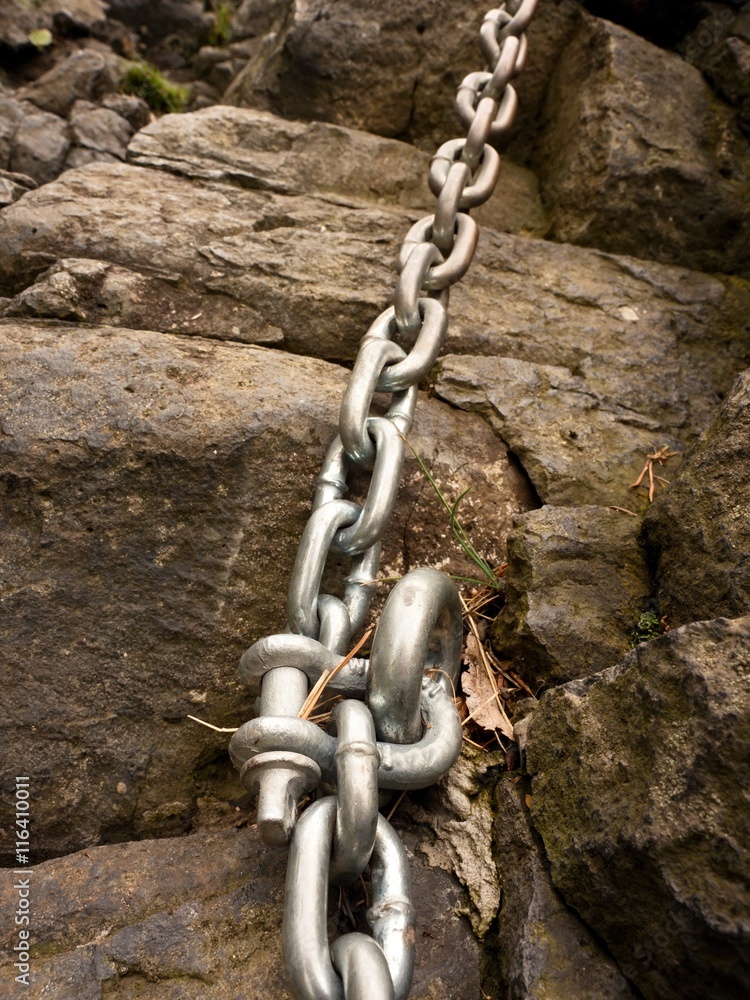 Steel bolt anchor eye in hard basalt rock. End of steel chain Steel bolt anchor eye in hard basalt rock. End of steel chain