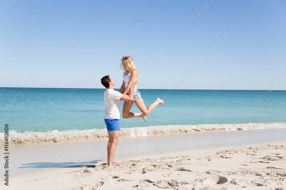 Happy couple jumping on beach vacations Happy couple jumping on beach vacations