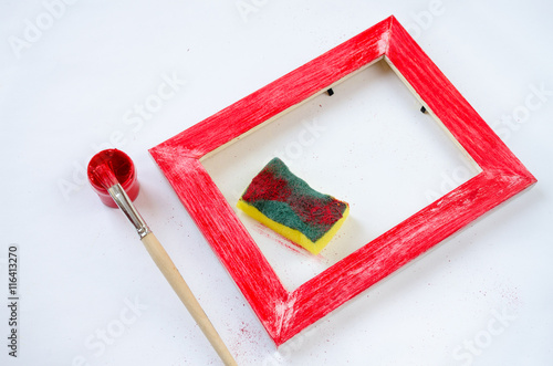 Painted wood picture frame with paint, sponge and paintbrush photo