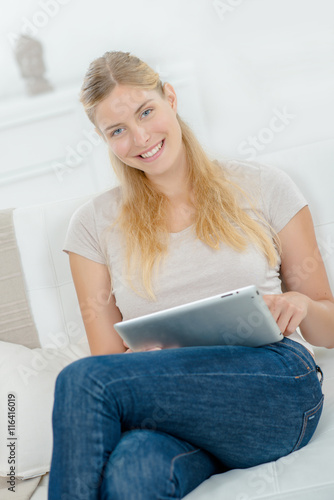 Woman sat on sofa with tablet computer