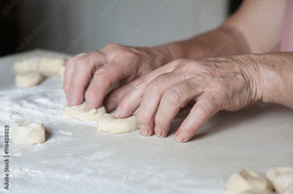 female hands crumple pieces of dough