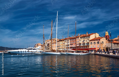 Photography Sailboats and yachts moored to the quay port of Saint-Tropez, France