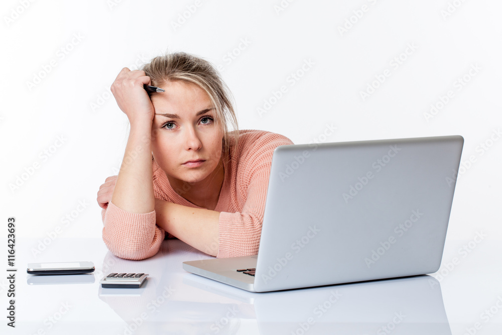 bored young blond woman working hard on her laptop bored young blond woman working hard on her laptop