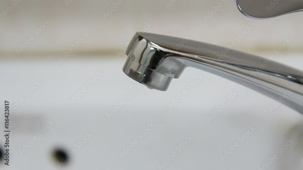 Water drop from faucet in the bathroom Water drop from faucet in the bathroom