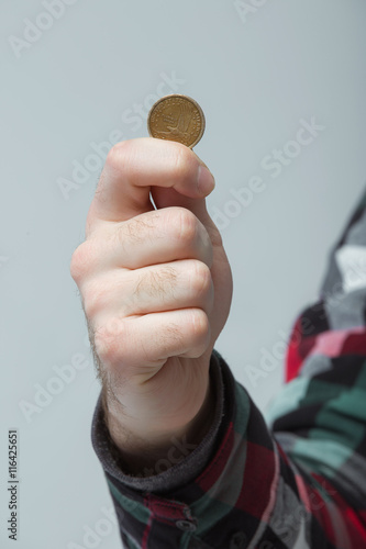 man's hand holding a coin, shows