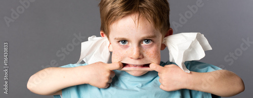 playful boy not listening with tissue in both ears