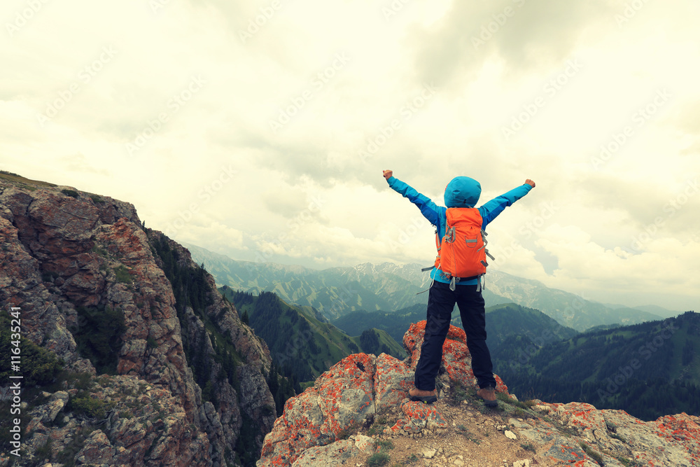 cheering successful woman backpacker open arms on mountain peak cheering successful woman backpacker open arms on mountain peak