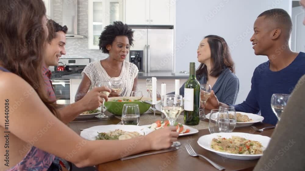 Friends making a toast at a dinner table, slow motion Friends making a toast at a dinner table, slow motion