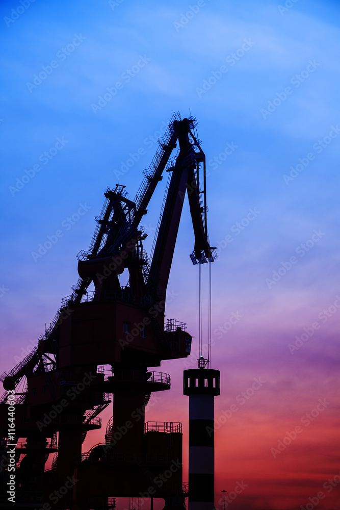 In the evening, the silhouette of port cranes In the evening, the silhouette of port cranes