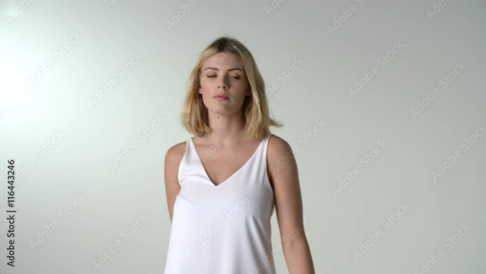 Young blonde woman walks to camera, into focus, and turns Young blonde woman walks to camera, into focus, and turns