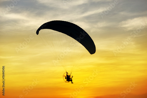фотографія silhouette of para motor glider