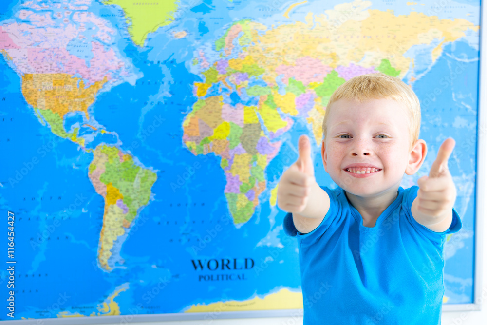 Preschool boy with world map, thumbs up Preschool boy with world map, thumbs up
