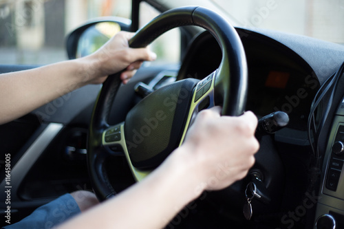 male driver hands holding steering wheel