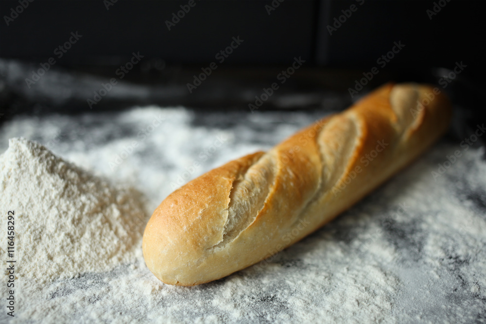 baguette with flour or meal in black backing tray