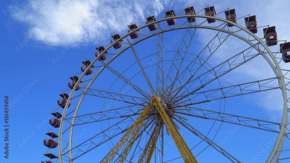 Ferris wheel against the blue sky with white clouds. bottom view. Ferris wheel against the blue sky with white clouds. bottom view.