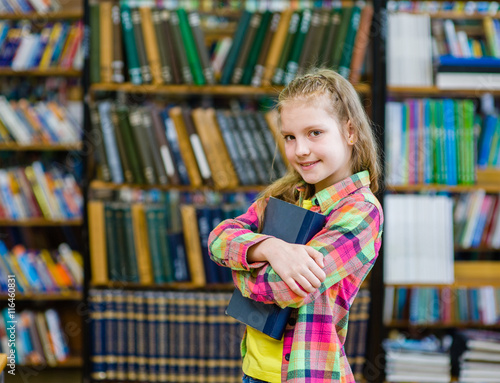 Teen girl embracing book in the library