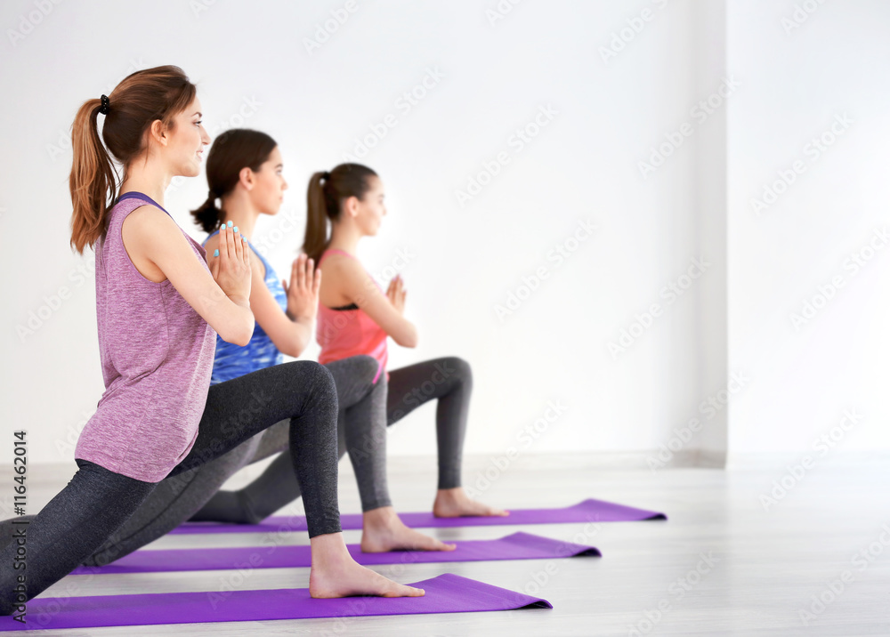 Obraz premium Young women with mats in gym