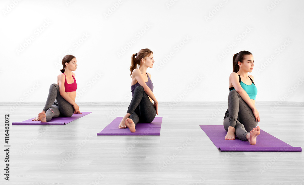 Naklejka premium Young women with mats in gym