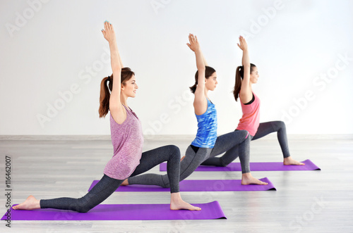 Young women with mats in gym