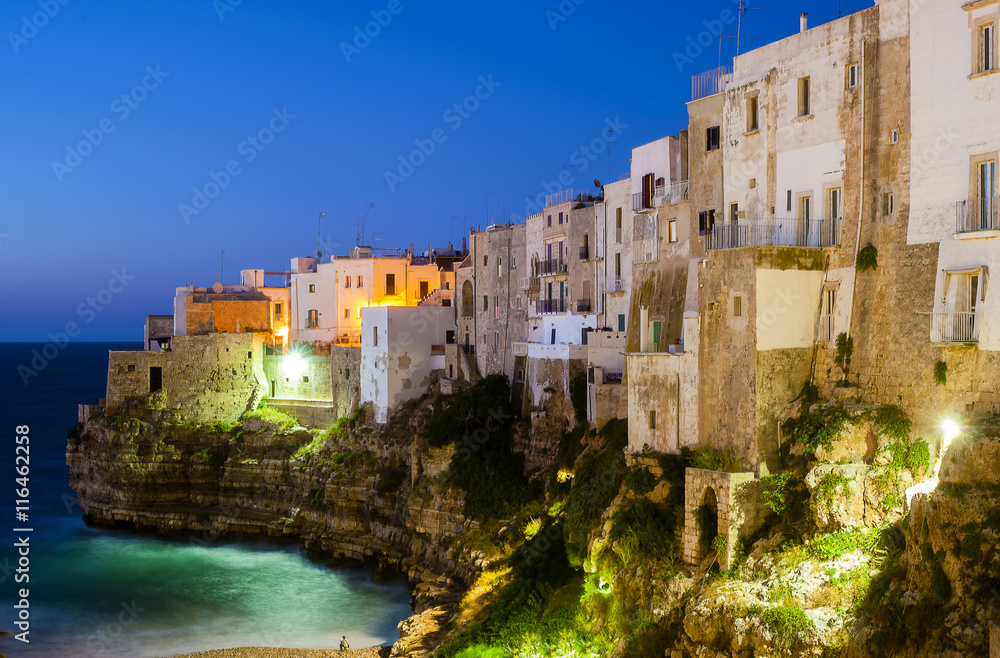 Polignano a Mare at night. Sea and rocks. The old town above the sea