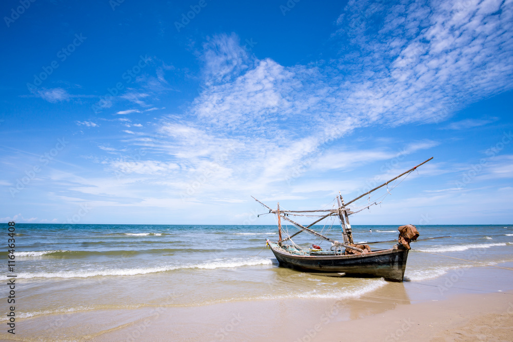 Old fishing boat and deep bluesky background at Hua Hin beach, Prachuap Khiri Khan Province, Thailand.