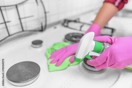 Hands in gloves are washed the gas stove.