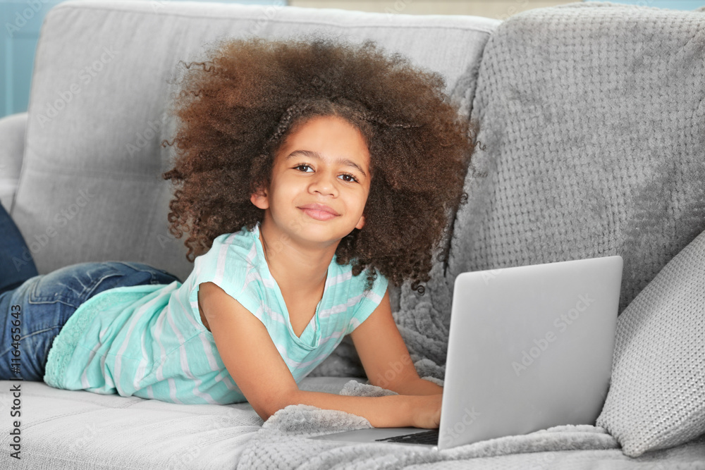 Cute African girl with laptop on couch Cute African girl with laptop on couch