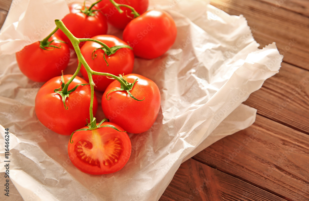 Bunch of red tomatoes in paper on wooden background Bunch of red tomatoes in paper on wooden background