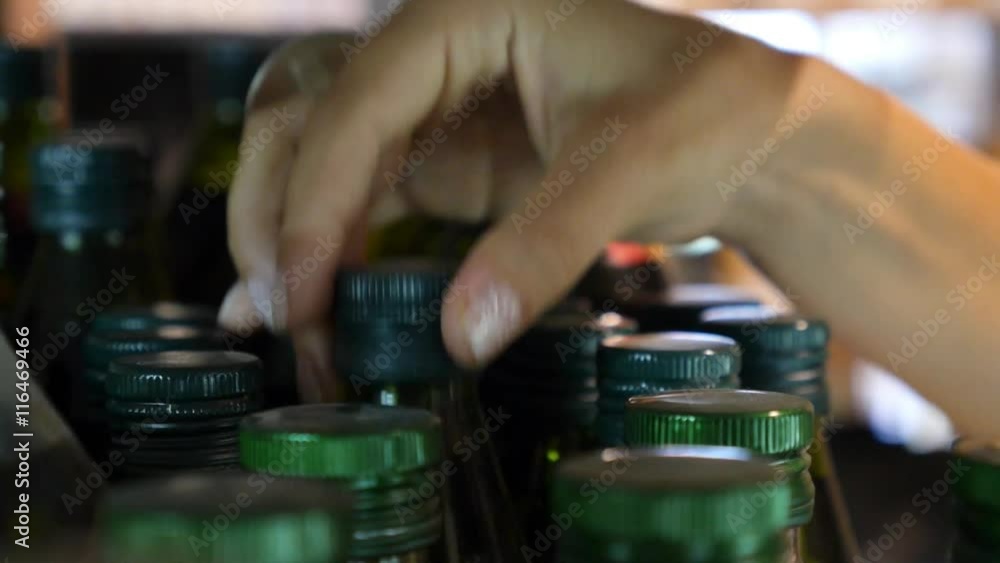 Female Hand Choosing Bottle of Olive Oil in Supermarket Female Hand Choosing Bottle of Olive Oil in Supermarket
