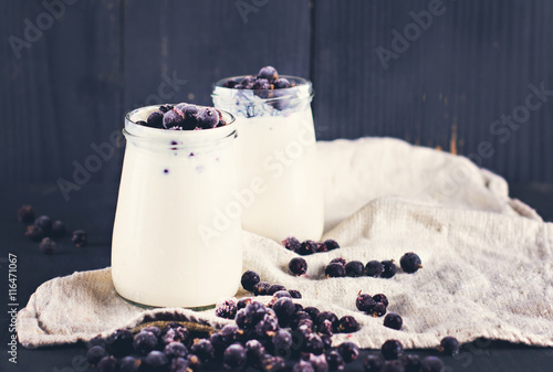 natural yoghurt with a black currant. Glass 0f yogurt with granola and black currants. photo