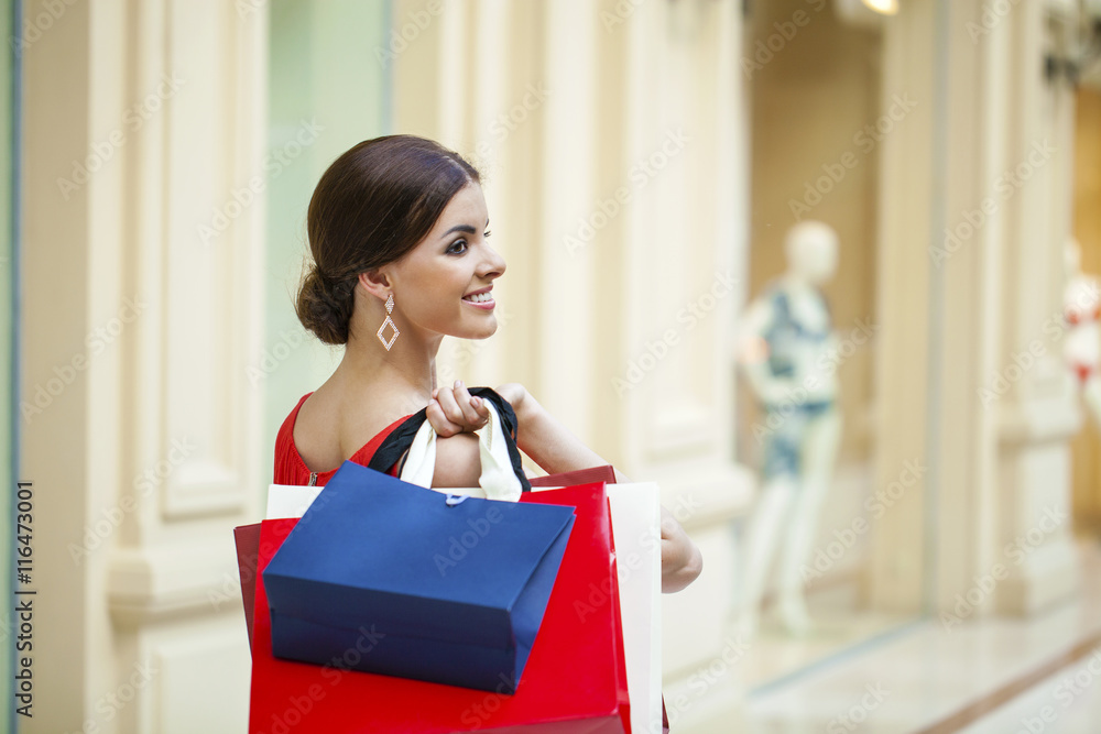 Fototapeta premium Happy brunette woman with some red shopping bag