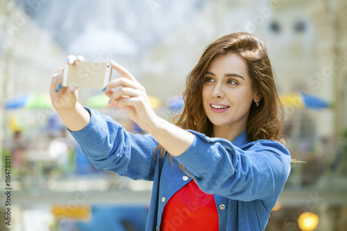 beautiful, smiling woman take a picture of herself with a smartp photo