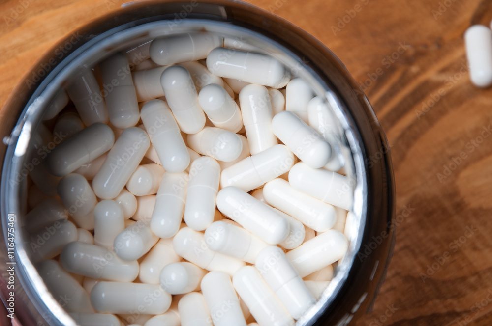 Creatine tablets on a wooden table Creatine tablets on a wooden table