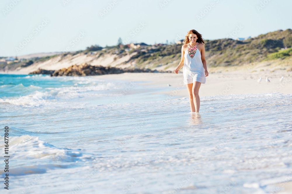 Young woman walking along the beach