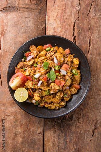 Indian snacks Bhel Puri served with chopped tomatoes, green chillies, coriander leaves photo