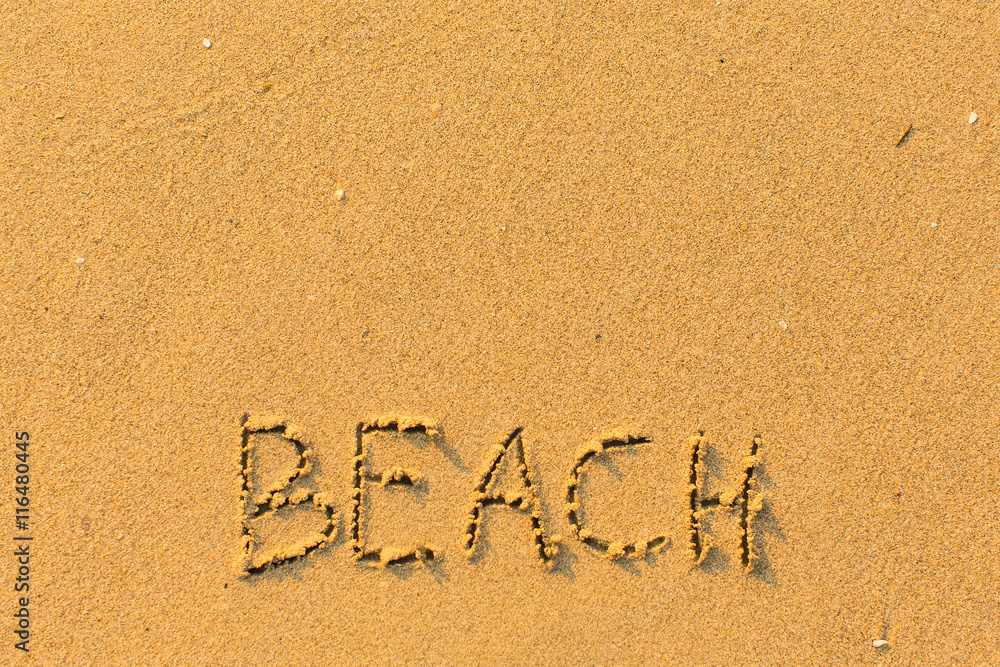 Beach - words hand-written on sand beach.