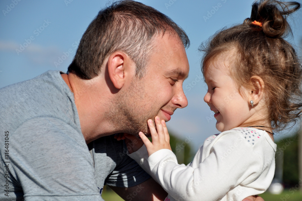Happy father with his daughter outdoors hugging together Happy father with his daughter outdoors hugging together