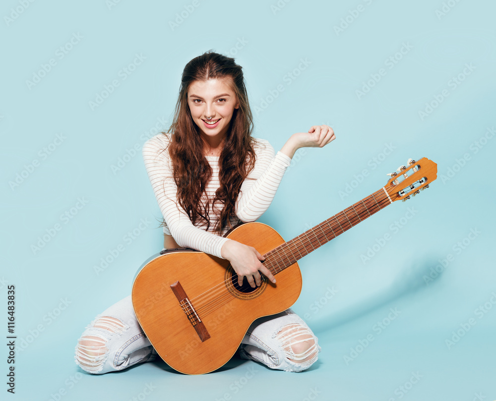 young artist pose seated in studio background with electric guitar in his  lap. he is wearing sunglasses while looking away Stock Photo - Alamy