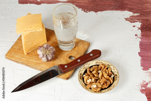 Still life with cheese, garlic, walnuts and mineral water photo