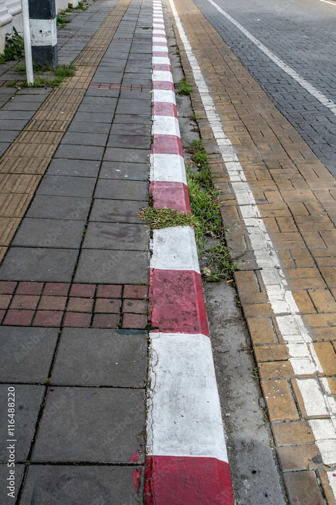 Concrete sidewalk with red and white