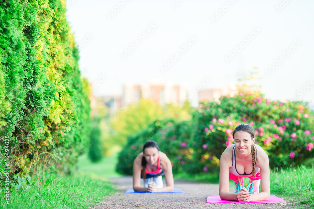 Sport fitness women training push-ups. Female athlete exercising push up outside in empty park. Fit girl fitness model in crossfit exercise outdoors. Healthy lifestyle concept. Sport fitness women training push-ups. Female athlete exercising push up outside in empty park. Fit girl fitness model in crossfit exercise outdoors. Healthy lifestyle concept.