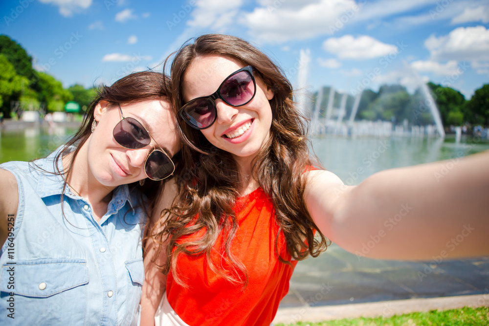 Caucasian girls making selfie background big fountain. Young tourist friends traveling on holidays outdoors smiling happy. Caucasian girls making selfie background big fountain. Young tourist friends traveling on holidays outdoors smiling happy.