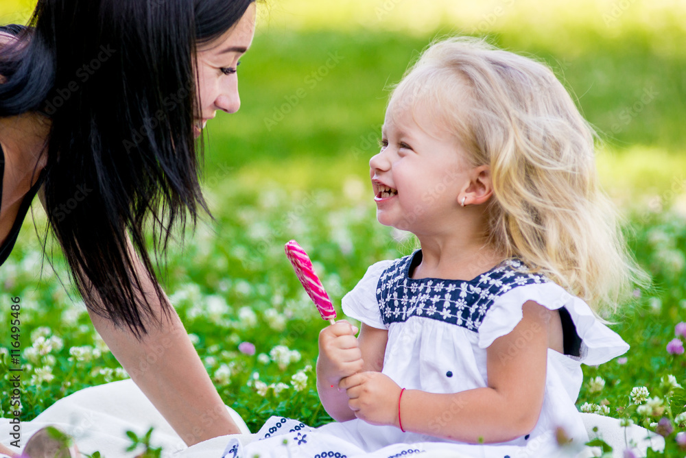 mother and daughter eating candy on a stick mother and daughter eating candy on a stick
