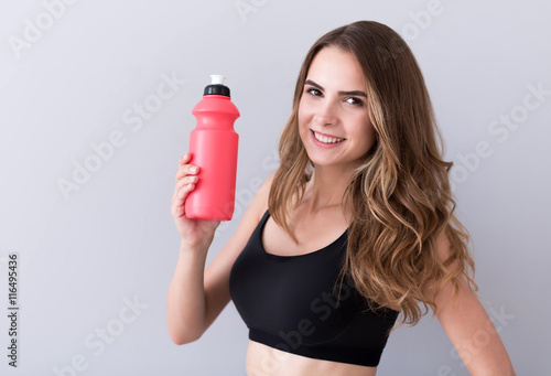Pleasant cheerful woman drinking water