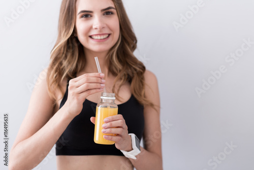 Joyful woman drinking orange juice.