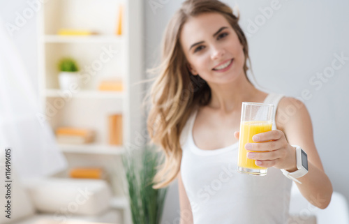 Cheerful smiling woman holding glass of juice