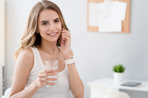Delighted smiling woman drinking water